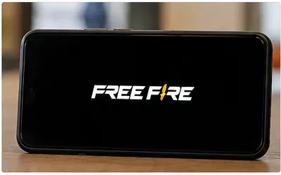 Logotipo de Free Fire mostrado en un teléfono sobre una pantalla de carga oscura.