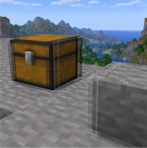 A chest and stone block have doubled edges on a path overlooking a block-built valley.