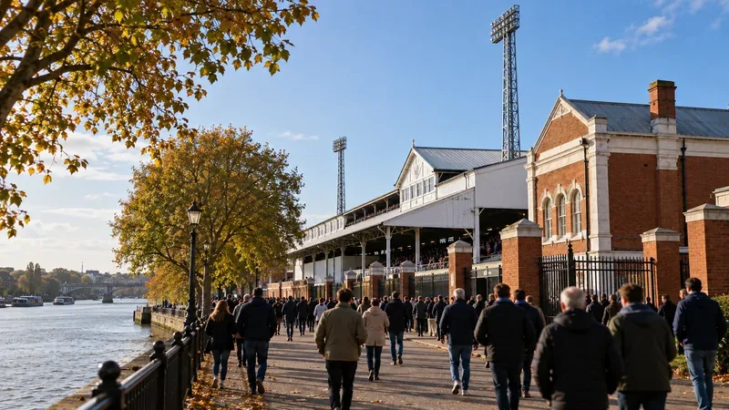 Supporters lopen op een wedstrijddag langs een doorsnee voetbalveld aan de rivier.