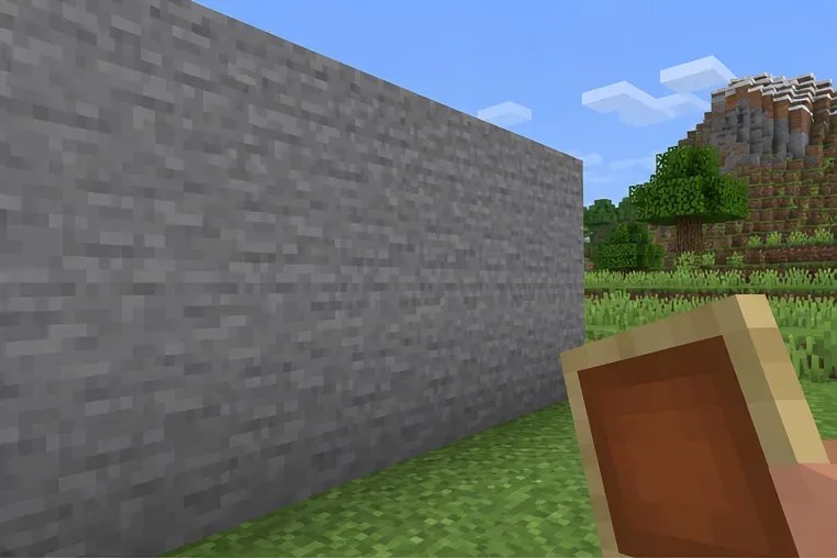 An empty stone wall with an item frame held nearby and no decorations around the target area.