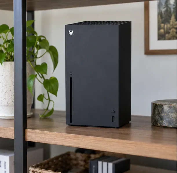 Xbox Series X standing on an open shelf with its top vent unobstructed and clear space around the console